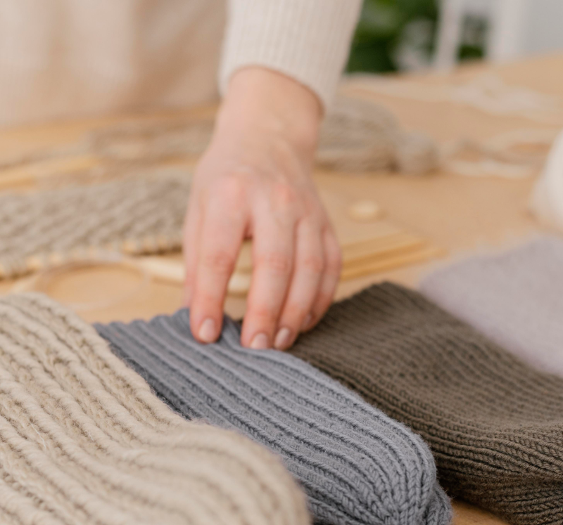 close-up-hand-touching-knitted-hats